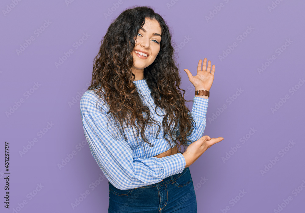Young hispanic girl wearing casual clothes inviting to enter smiling natural with open hand Young hispanic girl wearing casual clothes inviting to enter smiling natural with open hand
