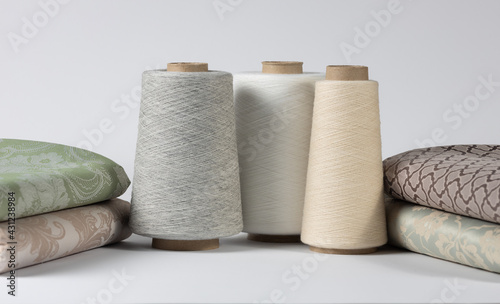 Vintage sewing thread on wooden spools with bed linen. on white isolated background. Copy space for text.