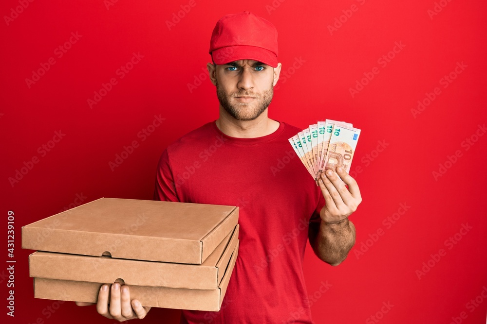 Young caucasian man holding take away food and 10 euros banknotes skeptic and nervous, frowning upset because of problem. negative person. Young caucasian man holding take away food and 10 euros banknotes skeptic and nervous, frowning upset because of problem. negative person.