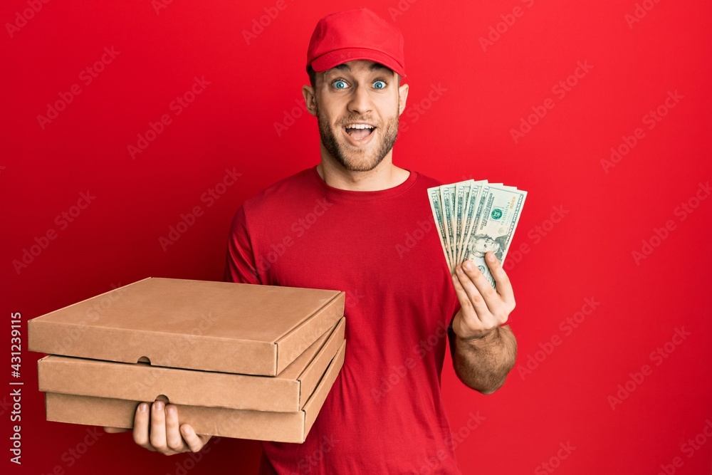 Young caucasian man holding take away food and 20 dollars celebrating crazy and amazed for success with open eyes screaming excited. Young caucasian man holding take away food and 20 dollars celebrating crazy and amazed for success with open eyes screaming excited.