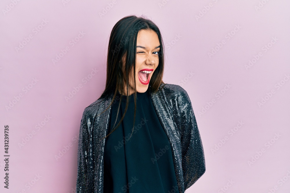 Young hispanic girl wearing party jacket winking looking at the camera with sexy expression, cheerful and happy face. Young hispanic girl wearing party jacket winking looking at the camera with sexy expression, cheerful and happy face.