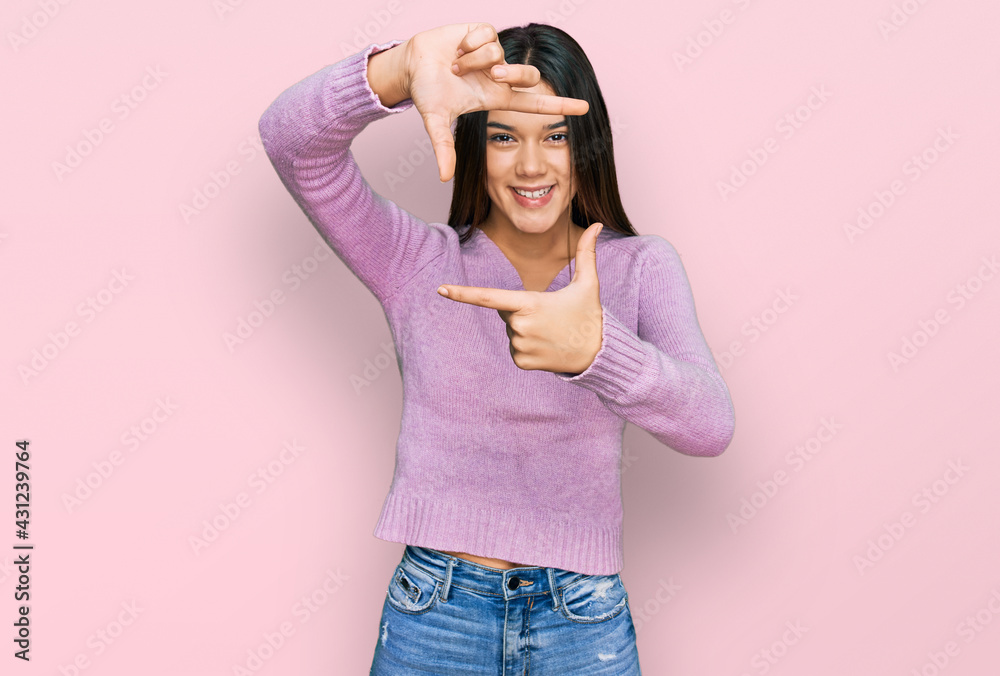 Young hispanic girl wearing casual clothes smiling making frame with hands and fingers with happy face. creativity and photography concept. Young hispanic girl wearing casual clothes smiling making frame with hands and fingers with happy face. creativity and photography concept.