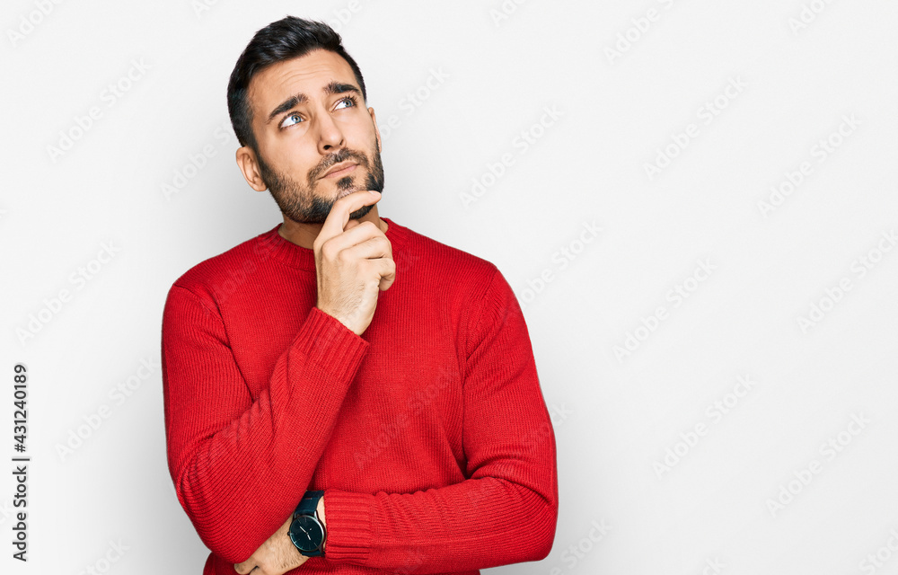 Young hispanic man wearing casual clothes with hand on chin thinking about question, pensive expression. smiling with thoughtful face. doubt concept. Young hispanic man wearing casual clothes with hand on chin thinking about question, pensive expression. smiling with thoughtful face. doubt concept.