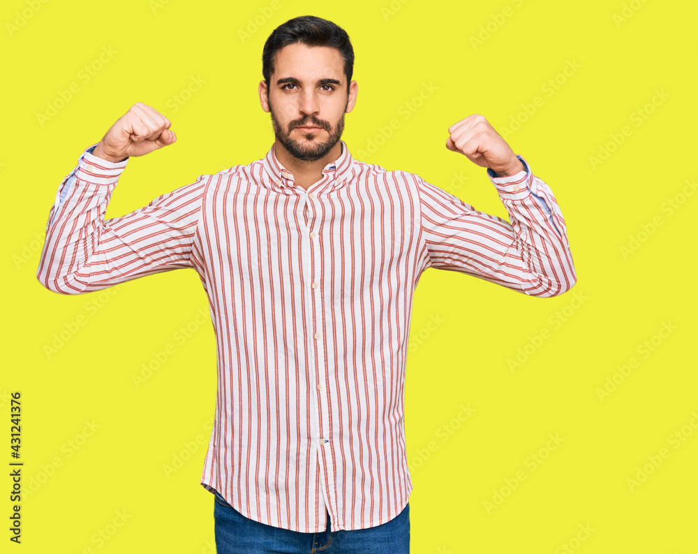 Young hispanic man wearing business shirt showing arms muscles smiling proud. fitness concept. Young hispanic man wearing business shirt showing arms muscles smiling proud. fitness concept.