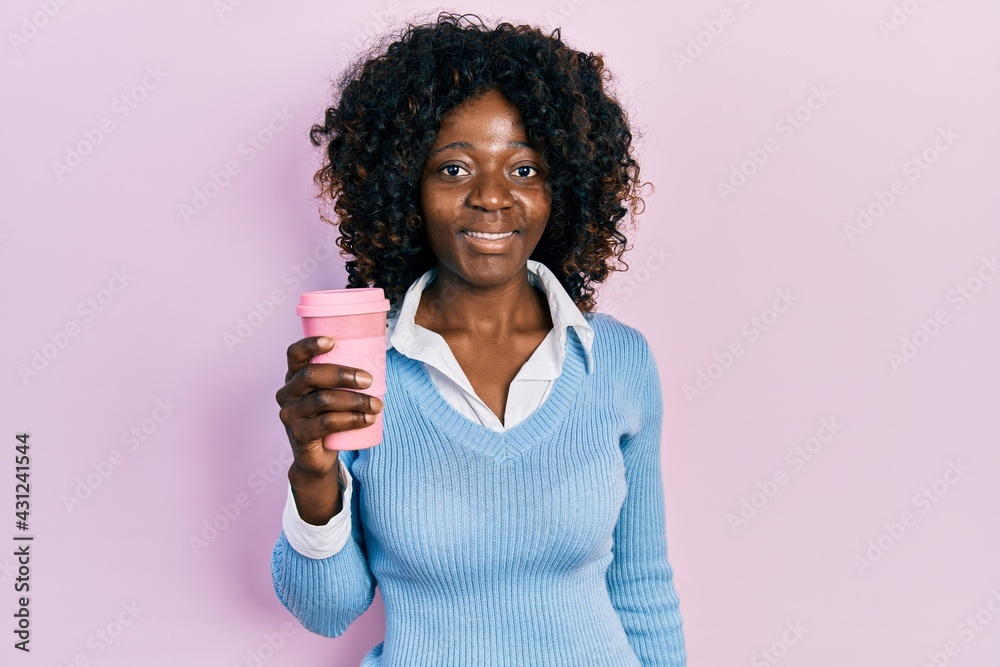 Young african american woman drinking take away coffee looking positive and happy standing and smiling with a confident smile showing teeth Young african american woman drinking take away coffee looking positive and happy standing and smiling with a confident smile showing teeth