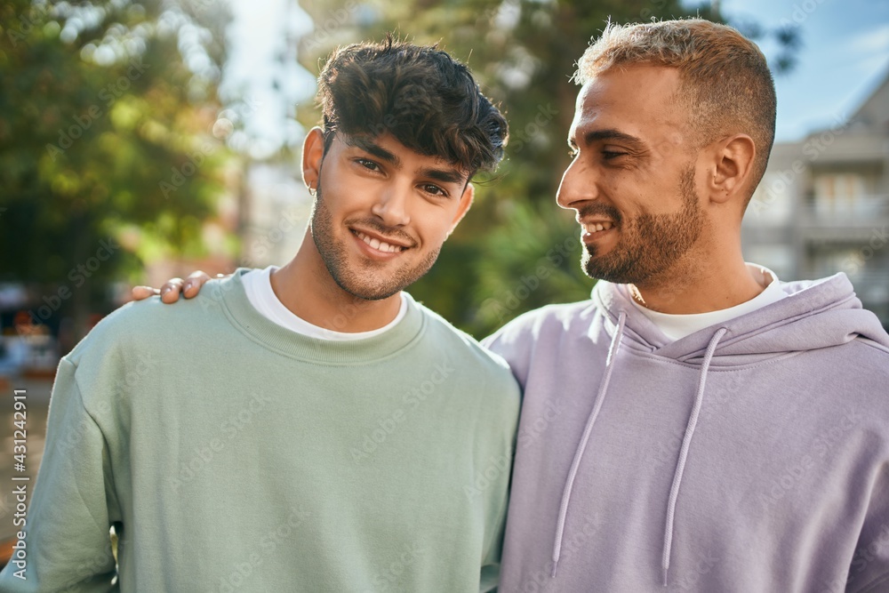 Young gay couple smiling happy and hugging at the city. Young gay couple smiling happy and hugging at the city.