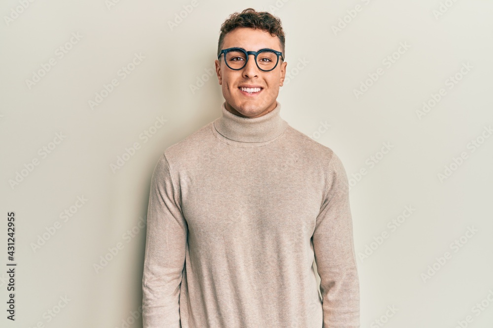 Hispanic young man wearing casual turtleneck sweater with a happy and cool smile on face. lucky person. Hispanic young man wearing casual turtleneck sweater with a happy and cool smile on face. lucky person.