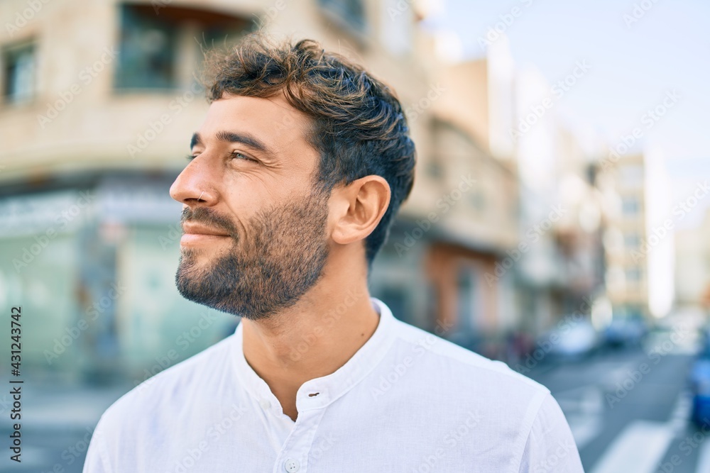 Handsome man with beard wearing casual white shirt on a sunny day smiling happy outdoors Handsome man with beard wearing casual white shirt on a sunny day smiling happy outdoors