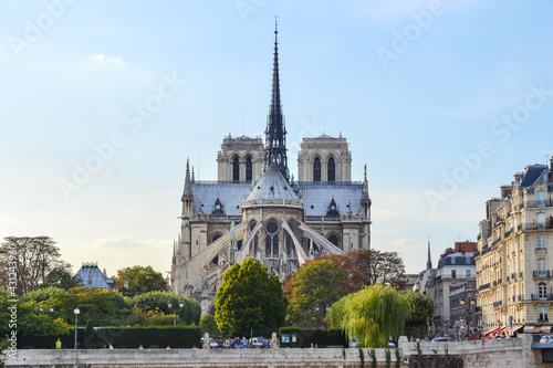 Rear view from Notre Dame Cathedral with spire in Paris, across Sena river, with blue and warn sky and almost no clouds