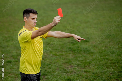 Obraz na plátne Angry football referee showing a red card and pointing with his hand on penalty