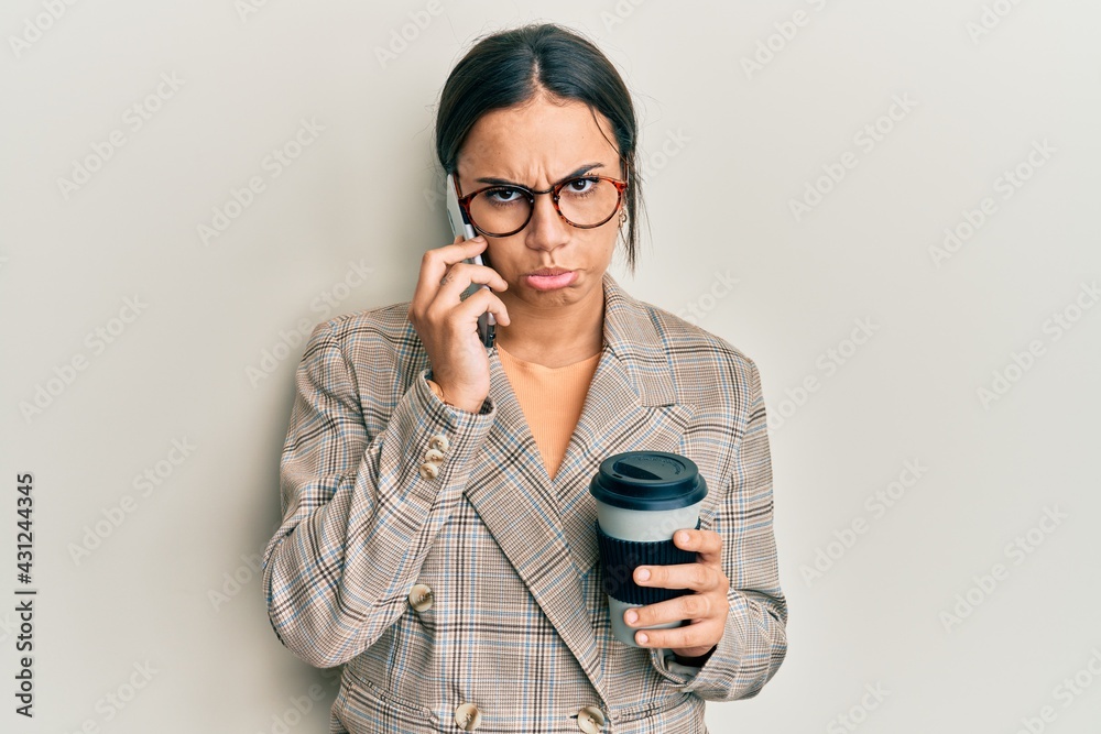 Young brunette woman using smartphone and drinking a cup of coffee depressed and worry for distress, crying angry and afraid. sad expression.