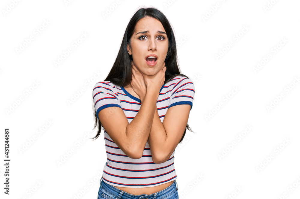 Young hispanic girl wearing casual striped t shirt shouting and suffocate because painful strangle. health problem. asphyxiate and suicide concept.