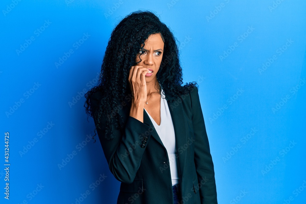 Middle age african american woman wearing business clothes looking stressed and nervous with hands on mouth biting nails. anxiety problem. Middle age african american woman wearing business clothes looking stressed and nervous with hands on mouth biting nails. anxiety problem.