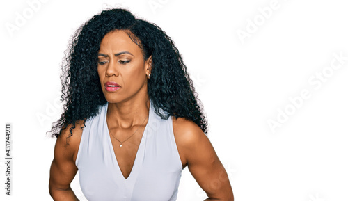 Middle age african american woman wearing casual style with sleeveless shirt with hand on stomach because indigestion, painful illness feeling unwell. ache concept.