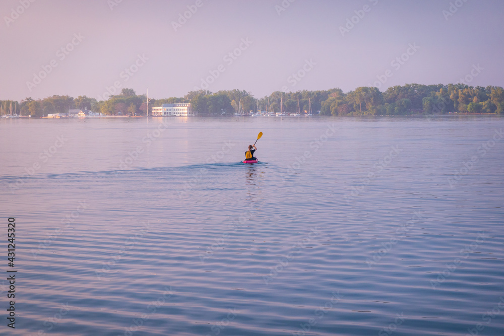An early morning kayaker heads across a foggy Toronto Inner Harbour toward the  Royal Canadian Yacht Club (RCYC) 
