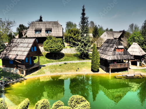 Ethno-village, traditional village houses made of logs, Bosnian style of construction in the highlands. Lake with water.Wooden architecture. photo