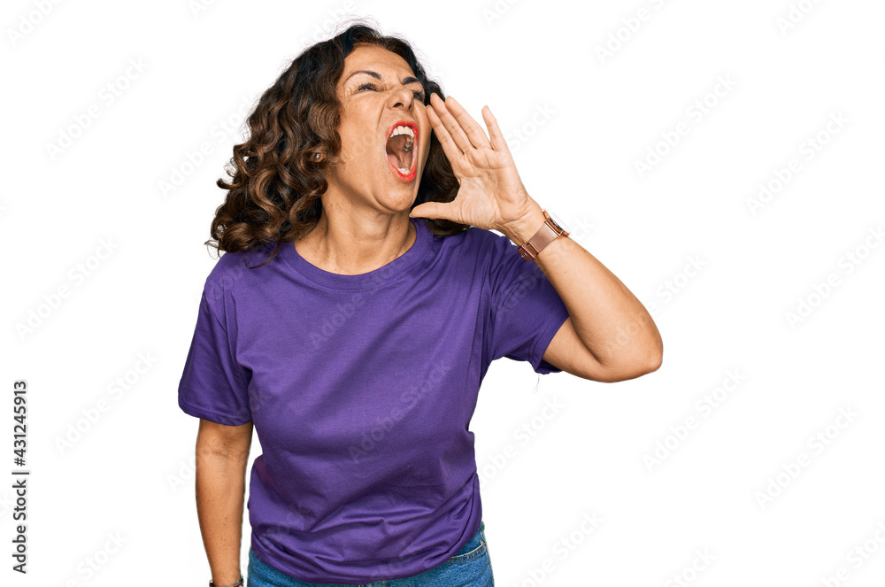 Middle age hispanic woman wearing casual clothes shouting and screaming loud to side with hand on mouth. communication concept. Middle age hispanic woman wearing casual clothes shouting and screaming loud to side with hand on mouth. communication concept.
