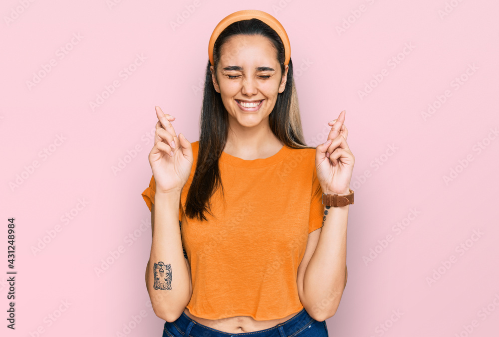 Young hispanic woman wearing casual clothes gesturing finger crossed smiling with hope and eyes closed. luck and superstitious concept. Young hispanic woman wearing casual clothes gesturing finger crossed smiling with hope and eyes closed. luck and superstitious concept.