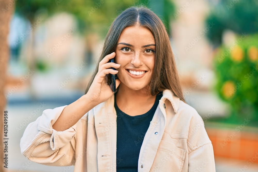 Young hispanic girl smiling happy talking on the smartphone at the park. Young hispanic girl smiling happy talking on the smartphone at the park.
