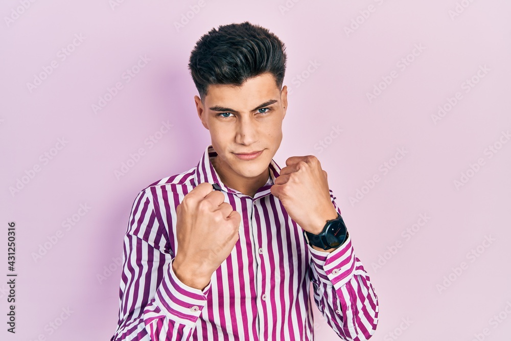 Young hispanic man wearing casual clothes ready to fight with fist defense gesture, angry and upset face, afraid of problem Young hispanic man wearing casual clothes ready to fight with fist defense gesture, angry and upset face, afraid of problem