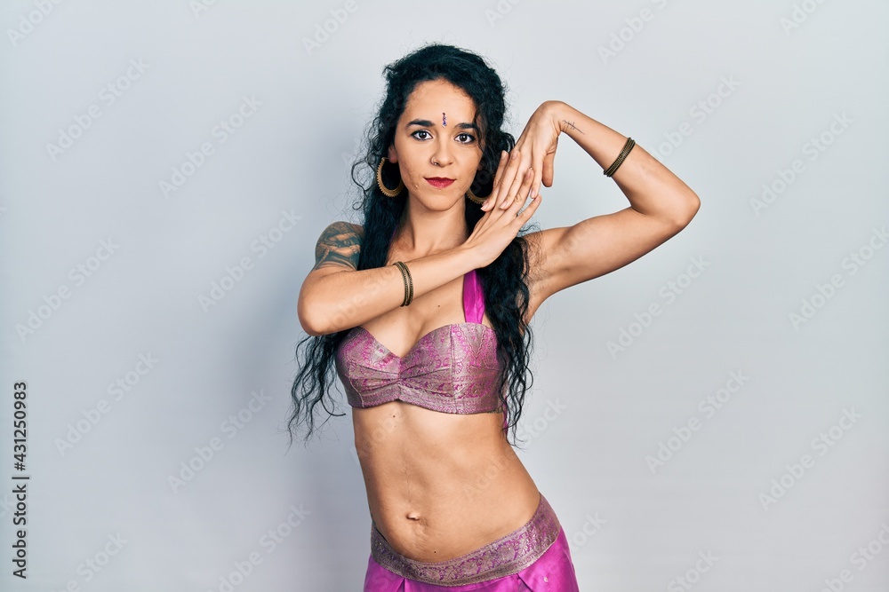 Young indian woman wearing traditional belly dancer costume. Dancing exotic oriental dance with body and hands