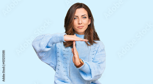 Photos Young brunette woman wearing casual winter sweater doing time out gesture with h