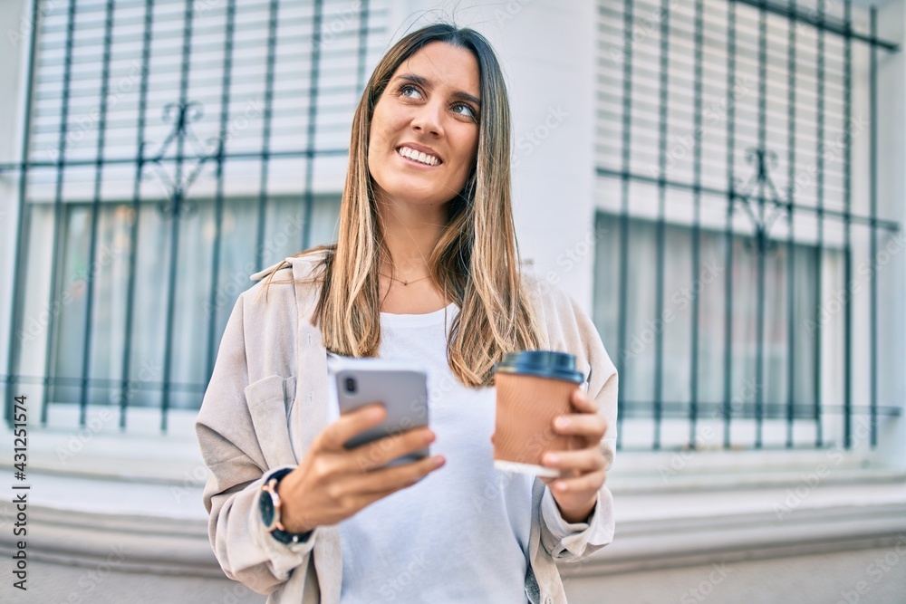 Young caucasian woman smiling happy using smartphone and drinking take away coffee at the city. Young caucasian woman smiling happy using smartphone and drinking take away coffee at the city.