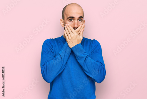 Young hispanic man wearing casual clothes shocked covering mouth with hands for mistake. secret concept.