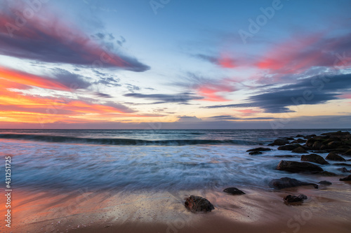Sunrise at the seaside with pastel coloured clouds