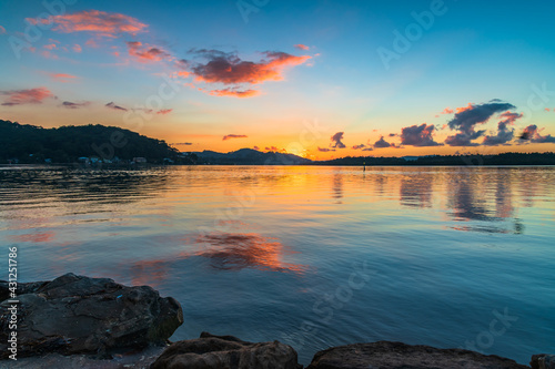 Sunrise waterscape with scattered clouds