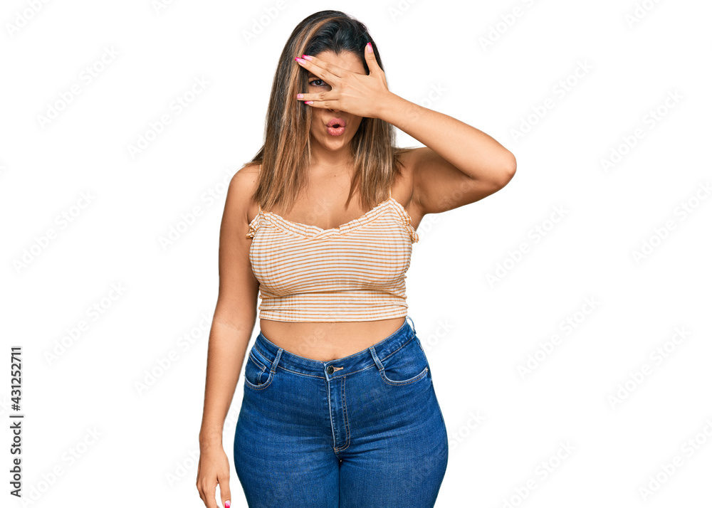Beautiful brunette woman wearing casual clothes peeking in shock covering face and eyes with hand, looking through fingers with embarrassed expression. Beautiful brunette woman wearing casual clothes peeking in shock covering face and eyes with hand, looking through fingers with embarrassed expression.