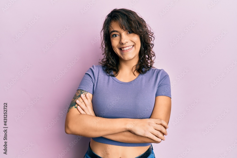 Young hispanic woman wearing casual clothes happy face smiling with crossed arms looking at the camera. positive person. Young hispanic woman wearing casual clothes happy face smiling with crossed arms looking at the camera. positive person.