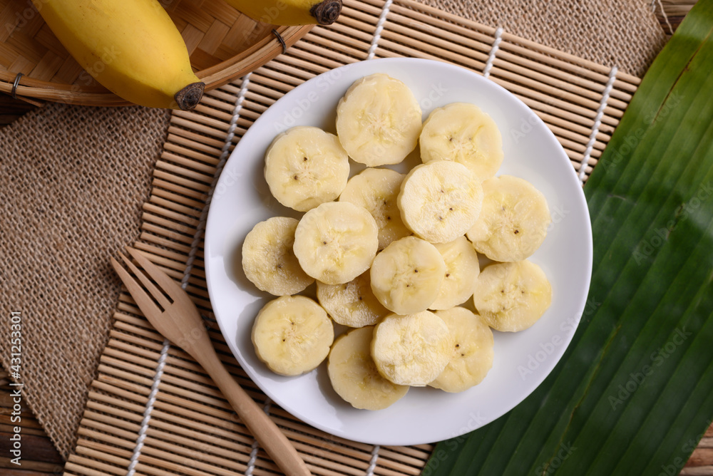 Sliced banana fruit on white dish with fork ready to eating, Tropical fruit Sliced banana fruit on white dish with fork ready to eating, Tropical fruit