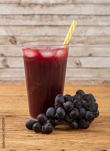 Wallpaper Mural Red grape juice in a glass with ice and fruits over wooden table Torontodigital.ca