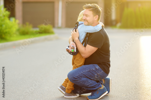 Fotografie Little boy says goodbye and hugging to his father before going to school