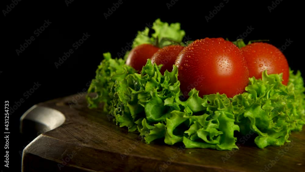 Yummy fresh 6 half dozen vine tomatoes on the bush on green lettuce leaves are turning on black background Yummy fresh 6 half dozen vine tomatoes on the bush on green lettuce leaves are turning on black background