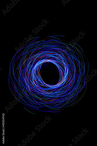 Wonderful and abstract round and parabolic patterns draw different light paths with LED ball lights on a dark background, pendulum.
