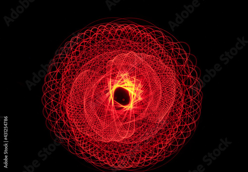 Wonderful and abstract round and parabolic patterns draw different light paths with LED ball lights on a dark background, pendulum.

