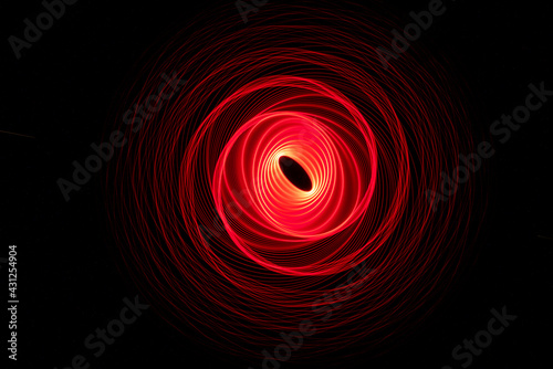 Wonderful and abstract round and parabolic patterns draw different light paths with LED ball lights on a dark background, pendulum.
