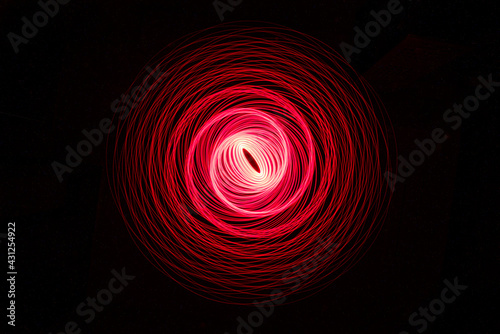 Wonderful and abstract round and parabolic patterns draw different light paths with LED ball lights on a dark background, pendulum. 