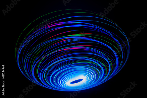 Wonderful and abstract round and parabolic patterns draw different light paths with LED ball lights on a dark background, pendulum.
