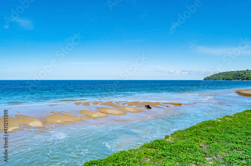 Summer background of Beautiful sandy beach Wave crashing on sandy shore Landscape nature view Romantic ocean bay with blue water and clear blue sky over sea at Phuket island Thailand
