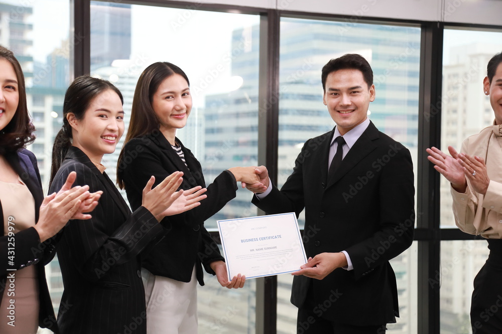 Group of Asian business corporation team celebrating together in the meeting room with CEO given certificate to the branch manager while the rest of employees are applauding Group of Asian business corporation team celebrating together in the meeting room with CEO given certificate to the branch manager while the rest of employees are applauding