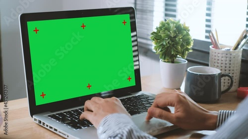 Business woman working in office interior on laptop computer on desk, Office person using laptop computer with chroma key green screen display.