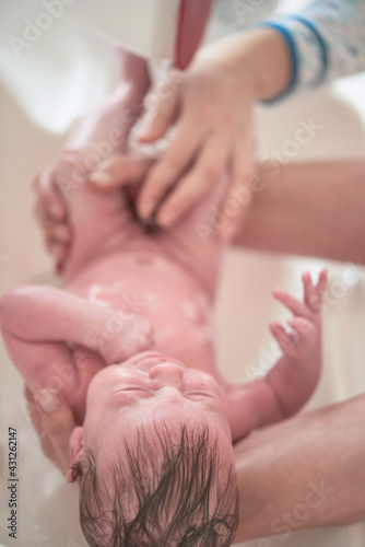 Newborn baby girl taking a bath