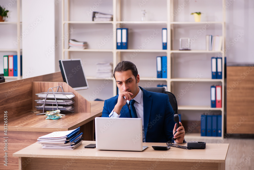 Young male employee working in the office Young male employee working in the office