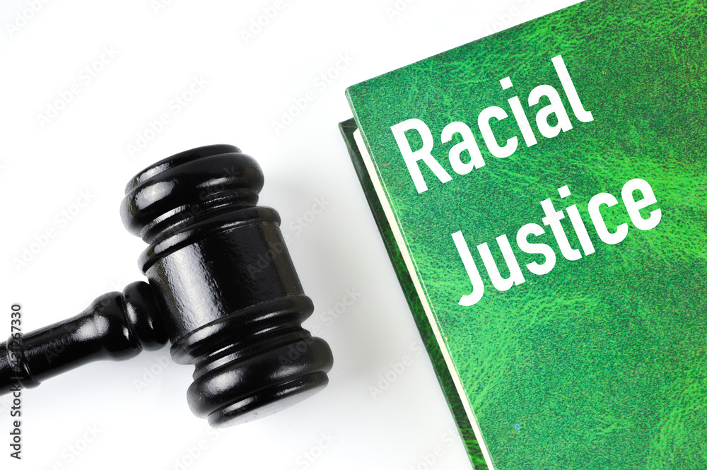 Judge gavel and green book written with RACIAL JUSTICE Judge gavel and green book written with RACIAL JUSTICE