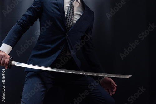 日本刀を構えるスーツ姿の人物