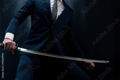日本刀を構えるスーツ姿の人物