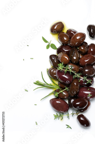 Olive nere ed erbe aromatiche su sfondo bianco. Direttamente sopra.